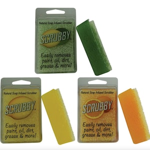 May include: Three packages of natural soap infused scrubbers. Each package has a different color scrubber: green, yellow, and orange. The packages have the text "SCRUBBY" and "Easily removes paint, oil, dirt, grease & more!" printed on them.