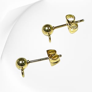 Peut inclure: Deux tiges d'oreille dorées avec une petite boule en haut et une boucle pour attacher un charme. Les tiges ont un dos papillon.