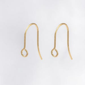 May include: Two gold-toned earring hooks. The hooks are made of metal and have a simple, elegant design.