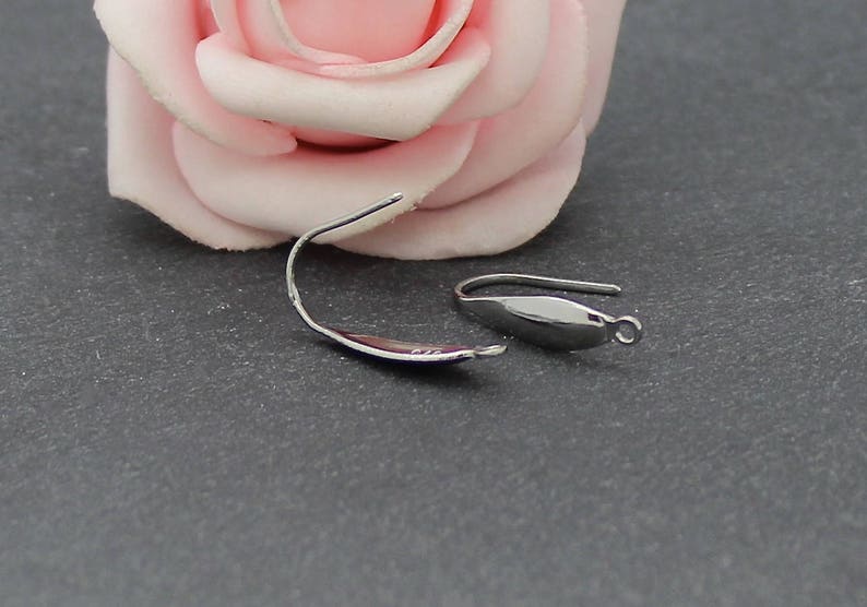 May include: Two silver-toned metal earring hooks with a curved, elongated leaf-like shape. Each hook features a smooth, polished finish and a small circular loop at the bottom end for attaching jewelry components, presented as a pair of findings.