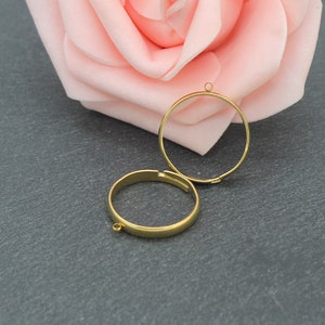 May include: Two gold-toned metal rings with jump rings. The rings are round and have a smooth finish.