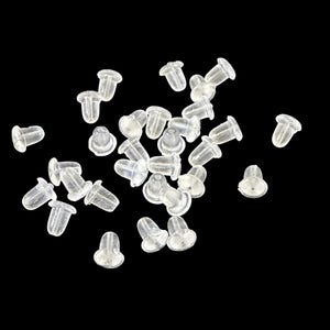 Peut inclure: Un ensemble de fermoirs d'oreilles transparents et translucides dispersés sur un fond noir. Les fermoirs sont petits, avec une base arrondie et un trou cylindrique.