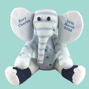 May include: A blue and white striped elephant soft toy with a blue and white patterned fabric body. The elephant has black button eyes and is personalised with the name "Rory Charles" and the date "24th March 2022".