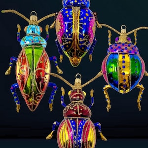 Puede incluir: Cuatro adornos de vidrio coloridos con forma de escarabajos con detalles dorados. Los escarabajos son azules, verdes, rojos y morados con detalles de purpurina dorada.