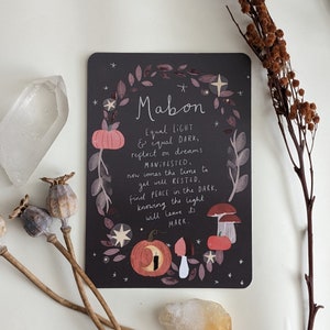 May include: A black card with a floral design and the text "Mabon Equal LIGHT & equal DARK, reflect on dreams MANIFESTED, now comes the time to get well RESTED, find PEACE in the DARK, knowing the light will leave its MARK."