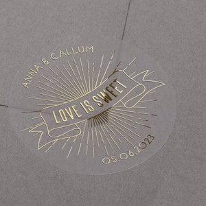Love is sweet foiled wedding stickers with personalised names and date. Gold print on semi clear matt sticker for wedding favours.
