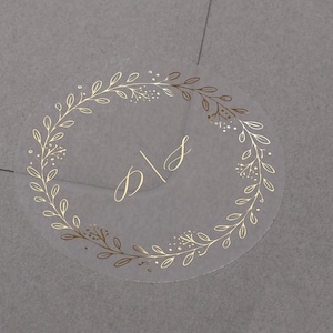 Verijdelde trouwstickers. Gepersonaliseerde initialen envelopzegels met krans. Gouden etiketten voor gunsten. Halfdoorzichtige, matte verlovingsstickers.