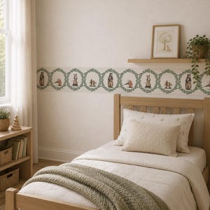 May include: A horizontal wallpaper border featuring a repeating pattern of green leafy circular wreaths, each enclosing a small illustration of a woodland animal, including bears and squirrels, applied to a light-colored wall above a wooden bed frame.