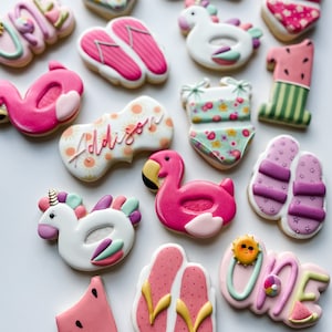 May include: A collection of decorated sugar cookies in a summer theme. The cookies include flip-flops, swimsuits, flamingos, unicorns, and watermelon slices. Some cookies have the name "Addison" and the number "one" written on them. The cookies are decorated with pink, white, and pastel colors.