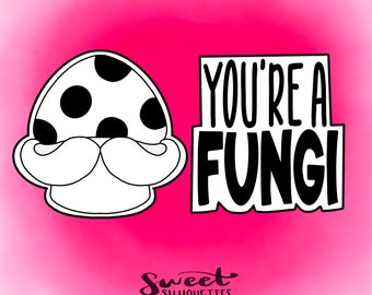 May include: A black and white cookie cutter shaped like a mushroom with a mustache. The cookie cutter is next to a white sign with black text that says "You're a Fungi".