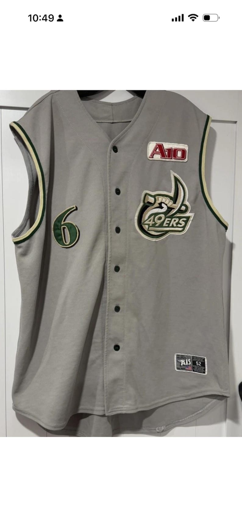 Op de afbeelding: Grijs honkbalshirt met groene en witte accenten. Voorzien van nummer 6, een patch met "A10" en een "49ERS" logo. Het shirt heeft een knoopsluiting en een label met "AIS 52".