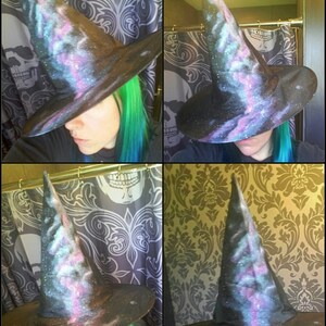 May include: A black witch hat with a galaxy print. The hat has a tall pointed crown and a wide brim. The galaxy print features shades of blue, purple, and pink.