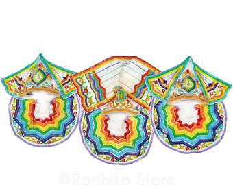 May include: A set of three white fabric garments with colorful embroidery. The garments are a hooded top, a long scarf, and a circular collar. The embroidery features a rainbow pattern with floral accents.