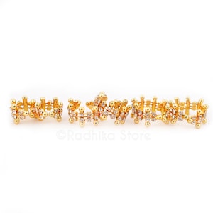 May include: Five gold-tone rings with clear rhinestones. The rings are connected together to form a chain.