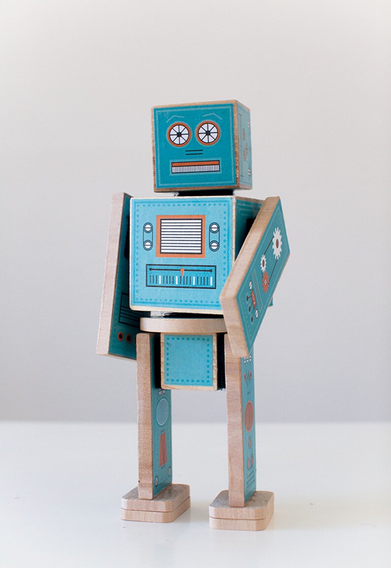 May include: A teal blue wooden robot toy with a printed face, buttons, and dials. The robot has movable arms and legs.