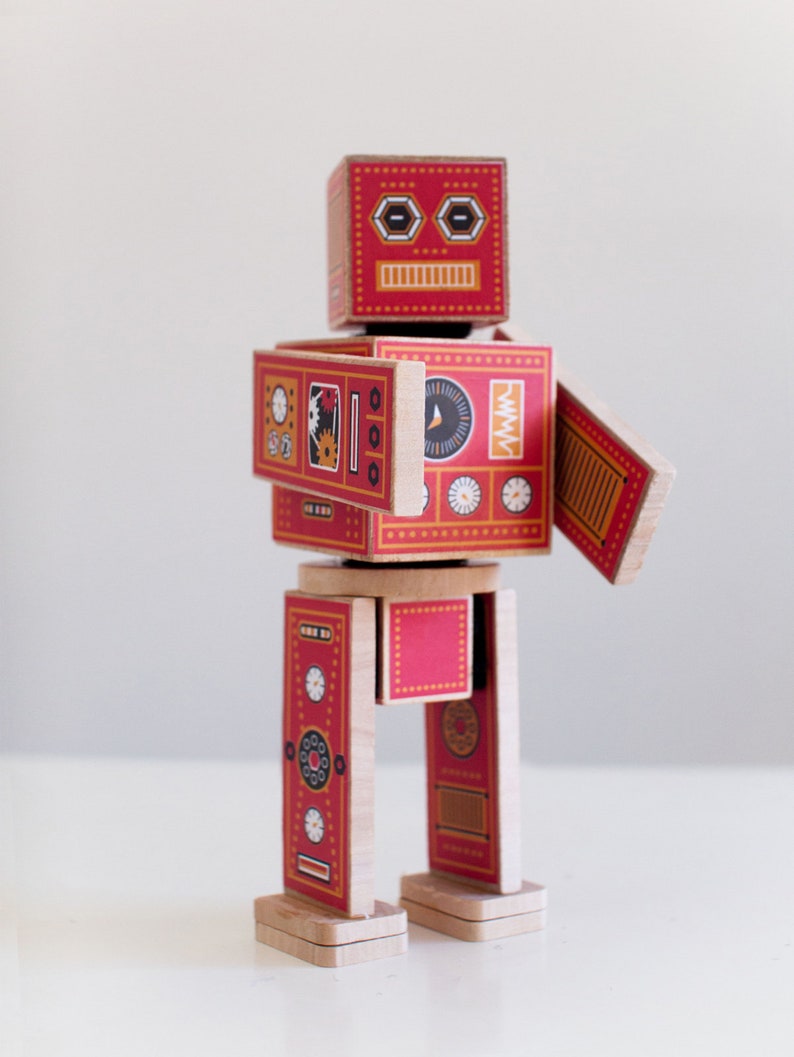 May include: A red and yellow wooden robot toy with a face, arms, and legs. The robot has a variety of details on its body, including gears, dials, and other mechanical elements.