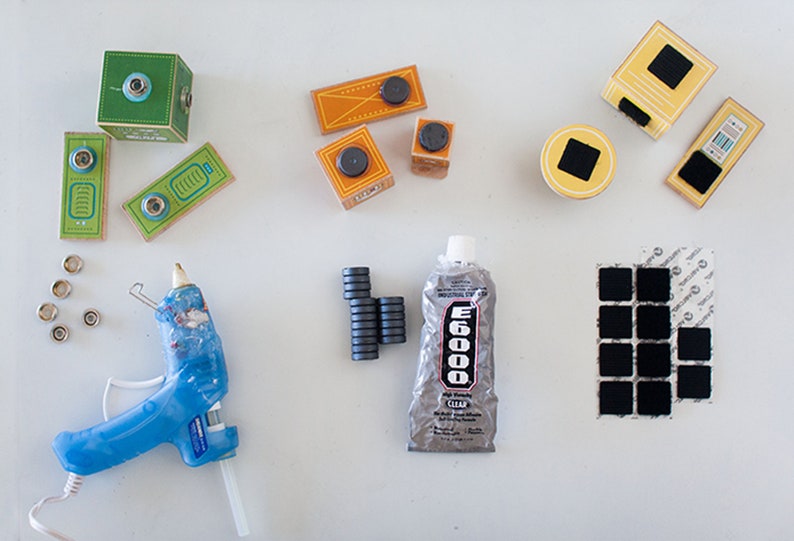 May include: A collection of craft supplies for making magnetic blocks. The supplies include wooden blocks, magnets, glue, adhesive squares, and a hot glue gun.