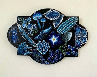 May include: A blue and black painted wooden plaque featuring a variety of blue botanical illustrations, including a mushroom, a snail, a flower, a cactus, a bird, and a butterfly.