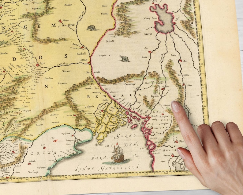 May include: An antique map of the Bengal region of India, showing the Bay of Bengal, the Ganges River, and surrounding areas. The map is hand-drawn and features intricate details, including mountains, rivers, and cities. The map is printed on paper and has a yellowed, aged appearance.