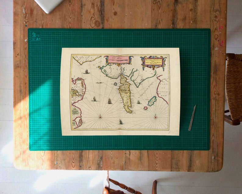 May include: An antique map of the Dutch East Indies, part of the Bay of Bengal, printed on aged paper with a compass rose and decorative borders.