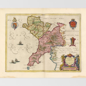 May include: An antique map of Ireland, showing the counties of the island. The map is in a vintage style, with hand-drawn lines and lettering. The map is colored in shades of green, pink, and yellow, and features a coat of arms in the upper right corner.