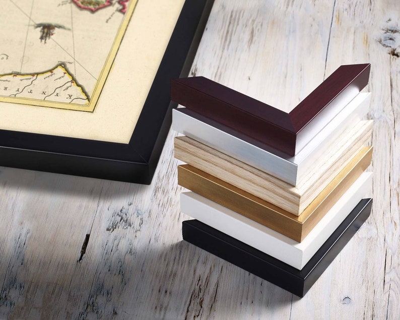 May include: A stack of picture frames in various colors, including black, white, brown, and gold. The frames are made of wood and have a simple, classic design.