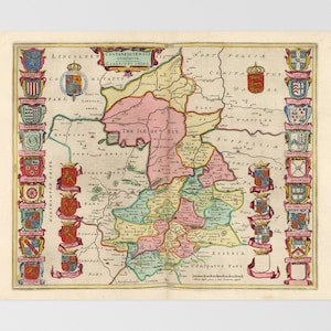 May include: A vintage map of England, showing the counties of Essex, Suffolk, Norfolk, Cambridge, Huntingdon, Bedford, Northampton, Lincoln, and the Isle of Ely. The map is hand-colored and features coats of arms for each county.