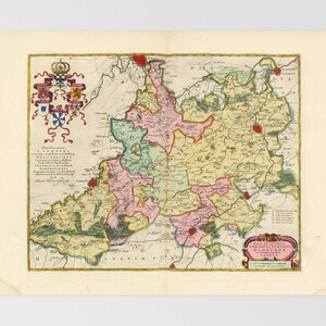 Puede incluir: Antiguo mapa de una región, con cartografía detallada y diversos colores que delimitan territorios. El mapa incluye texto, un escudo decorativo y un borde. El papel es de color crema.