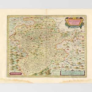 Op de afbeelding: Een antieke kaart van Westfalen, Duitsland, uit de 17e eeuw. De kaart is met de hand getekend en toont gedetailleerde kenmerken, waaronder rivieren, bergen en steden. De titel "Westphalia Ducatus" staat in een decoratief banner bovenaan de kaart.