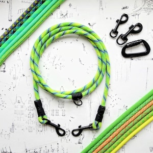 May include: A lime green and blue dog leash with black metal clips and a black carabiner. Several other dog leashes in shades of green and yellow are also visible. The leashes are made of a thick, durable rope material.