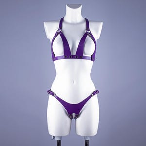 May include: Purple leather lingerie set with a halter top and a thong bottom. The set features multiple straps and buckles.