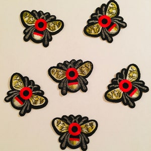 Puede incluir: Seis parches bordados para planchar de abejas con alas negras y doradas y cuerpos rojos y negros.