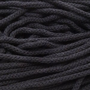 May include: A close-up of a pile of black cotton cord. The cord is thick and textured, and it is perfect for crafting projects.
