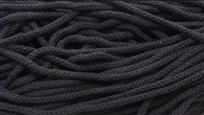 May include: A close-up of a pile of black cotton cord. The cord is thick and textured, and it is perfect for crafting projects.
