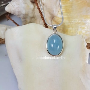 May include: A silver chain necklace with a light blue oval pendant. The pendant is set in silver and has a smooth, polished finish.