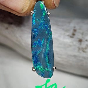 May include: A teardrop-shaped pendant with a blue and green opal gemstone set in silver.