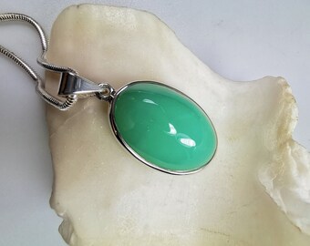 May include: A silver chain necklace with a green oval gemstone pendant.
