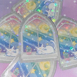 May include: A set of four iridescent stickers featuring a white cat sleeping in a window with a crescent moon and stars. The window is framed in a gray archway with a rainbow gradient background.