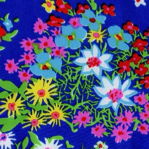K&ouml;nnte beinhalten: Ein blauer Stoff mit einem Blumenmuster. Die Blumen sind in den Farben Rot, Rosa, Gelb, Wei&szlig; und Blau.