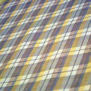May include: A white fabric with a checkered pattern in shades of yellow, blue, and brown.