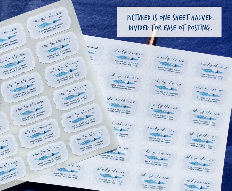 May include: Sheets of white labels with a blue and white design, featuring the text "she by the sea." The labels have a decorative border and include text about custom prints and labels. The image also includes the text: "PICTURED IS ONE SHEET HALVED. DIVIDED FOR EASE OF POSTING."