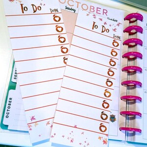 May include: White To Do list inserts with red lines and apple graphics. The words "To Do" and "Done" are printed in brown. The inserts are decorated with fall leaves and are attached to a pink binder.