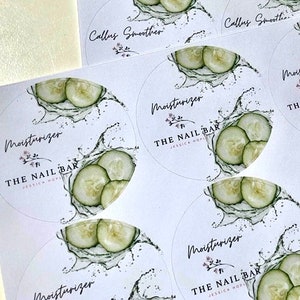May include: White circular stickers with a cucumber and water splash design. The stickers have the text "Moisturizer" and "The Nail Bar" with a floral accent. Some stickers also say "Callus Smoother".