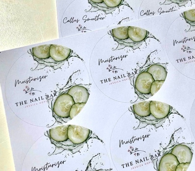 May include: White circular stickers with a cucumber and water splash design. The stickers have the text "Moisturizer" and "The Nail Bar" with a floral accent. Some stickers also say "Callus Smoother".