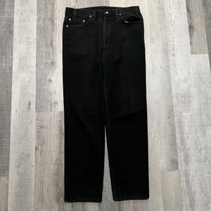 May include: A pair of black denim jeans. The jeans have a classic five-pocket design with a button and zipper closure. The jeans are made of a sturdy denim material and have a straight leg fit. The jeans are a solid black color.