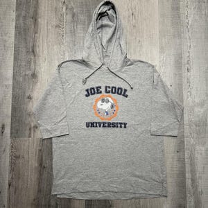 May include: A gray hooded sweatshirt with the text "JOE COOL UNIVERSITY" in navy blue. The sweatshirt features a graphic of Snoopy wearing sunglasses inside an orange circle. The sleeves are three-quarter length.