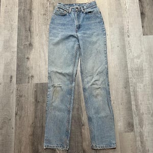 May include: Light blue denim jeans with a distressed knee and a high waist.