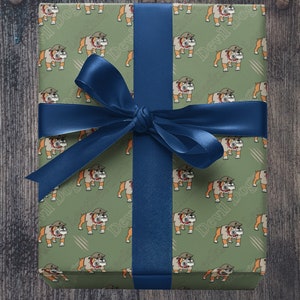 May include: A green gift box with a blue ribbon. The box is wrapped in paper with a repeating pattern of cartoon bulldogs wearing military helmets. The text "Devil Dogs" is printed on the paper.