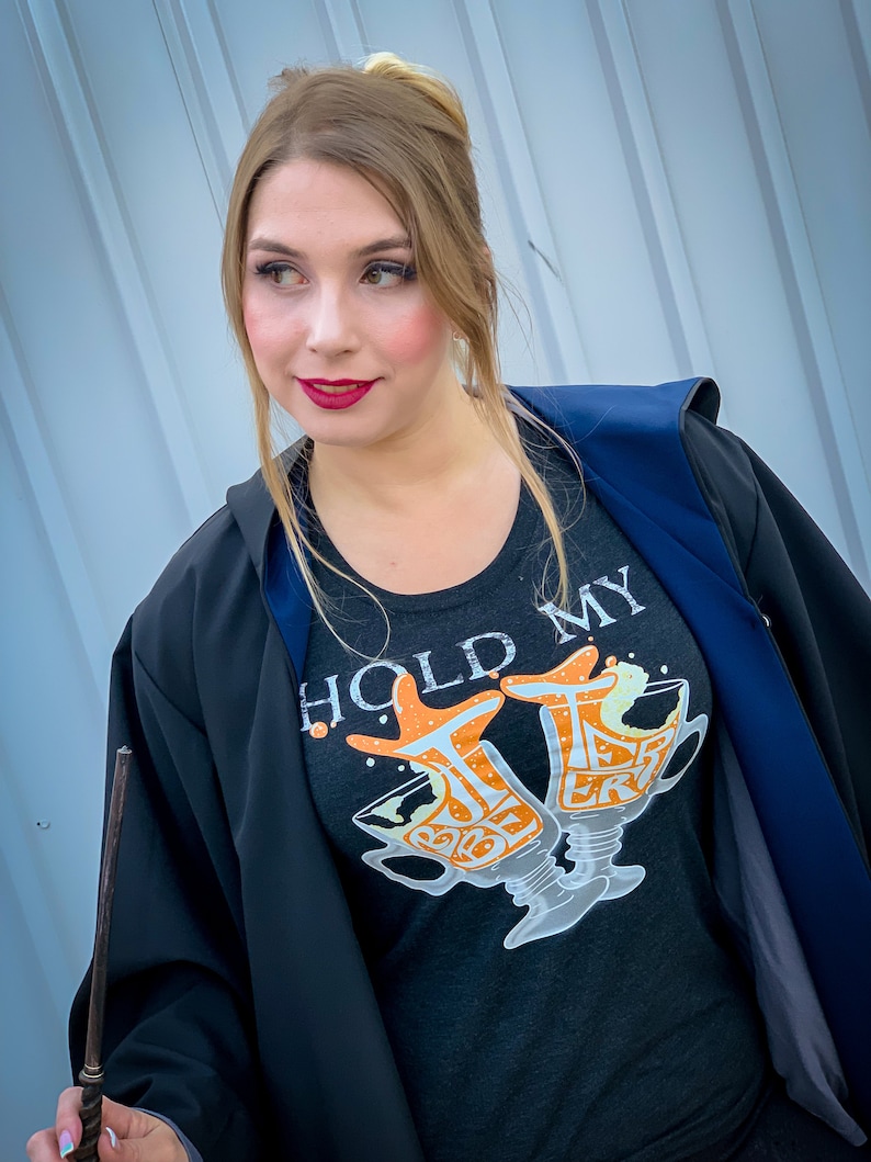 girl wearing hold my butterbeer t-shirt and robes