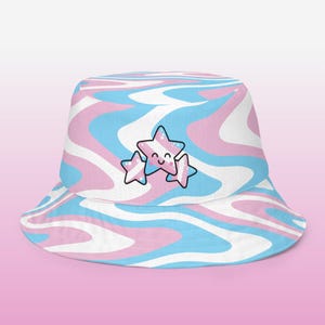 May include: Bucket hat with a swirling pattern in light blue, pink, and white. The hat features three smiling star graphics in the center. The hat is a stylish accessory for sun protection and self-expression.